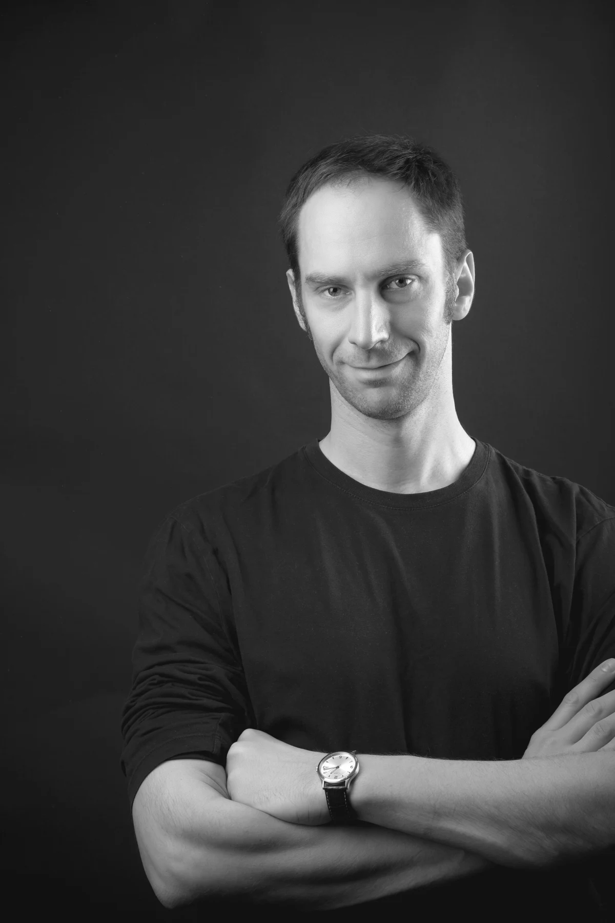 Victor Kautsch, lächelnd mit verschränkten Armen, Schwarz-Weiß-Porträt